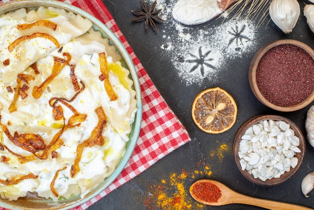 Photo gratuite vue de dessus des morceaux de pâte cuits avec des oignons frits et différents ingrédients sur le fond sombre plat de dîner photo cuisson de la farine d'huile alimentaire