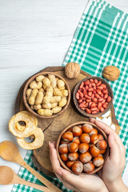 Vue de dessus des noisettes crues fraîches aux cacahuètes sur un tableau blanc