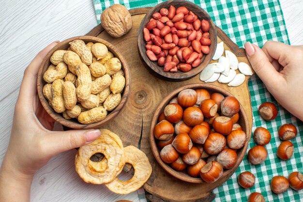 Vue de dessus des noisettes crues fraîches aux cacahuètes sur un tableau blanc