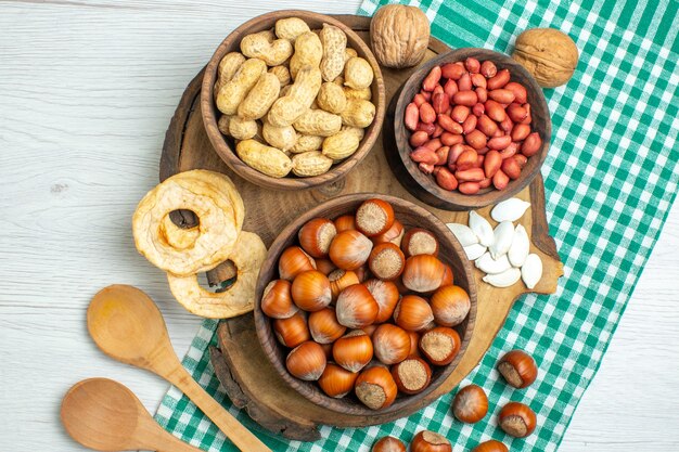 Vue de dessus des noisettes crues fraîches avec des cacahuètes sur des noix de table blanches