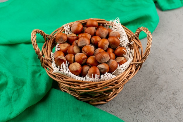 Vue de dessus noisettes entières à l'intérieur du panier sur le bureau gris