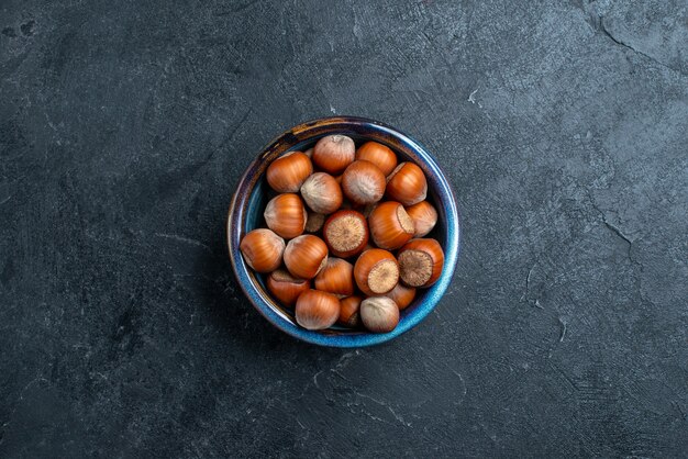 Vue de dessus de noisettes fraîches à l'intérieur de petit pot sur le fond sombre noisette noisette noix snack arachide