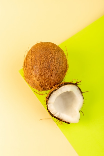 Une vue de dessus de noix de coco entier laiteux frais moelleux isolé sur la crème-pistache colorée