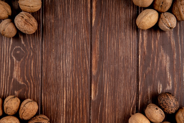 Vue de dessus de noix entières éparpillées sur fond de bois avec copie espace