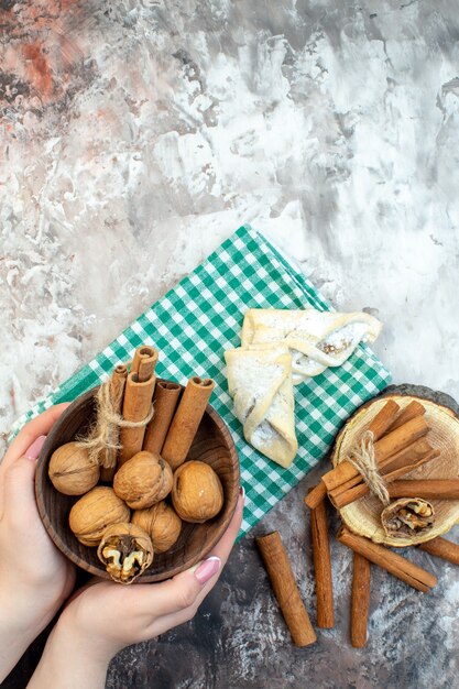 Vue de dessus des noix fraîches avec de la cannelle et des pâtisseries sucrées sur une surface légère