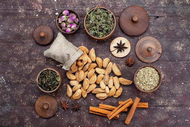 Une vue de dessus des noix fraîches salées et savoureuses avec de la cannelle sur le bureau en bois foncé snack noix noix