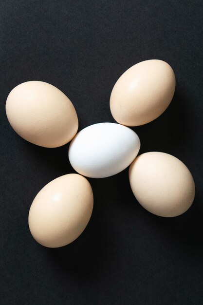 Une vue de dessus des œufs blancs crus entiers sur dark