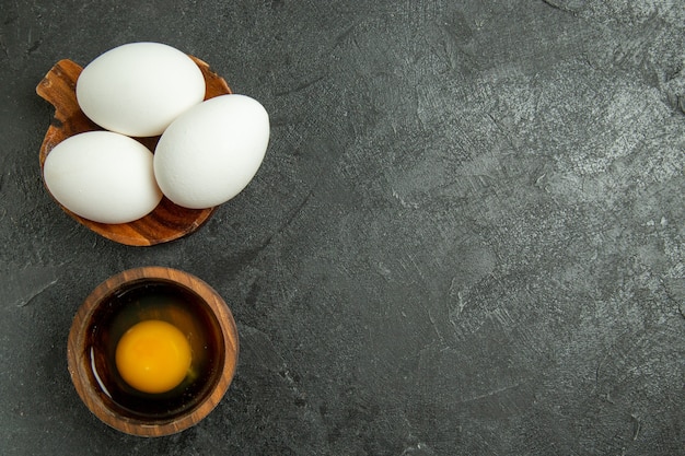 Vue de dessus des oeufs entiers crus sur fond gris oeuf petit déjeuner repas cru alimentaire