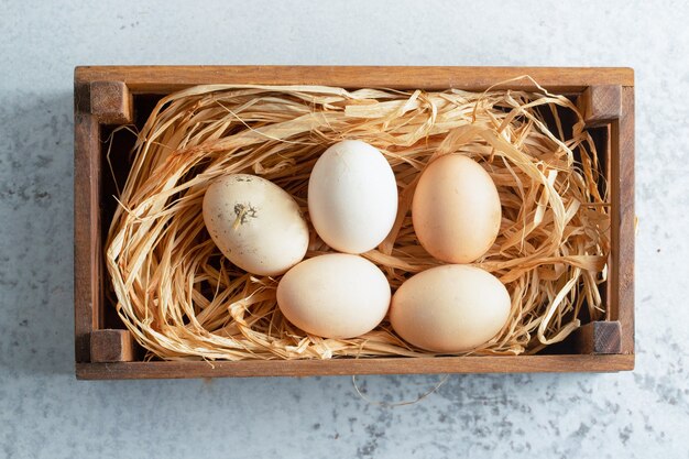 Vue de dessus des œufs frais dans une boîte en bois.