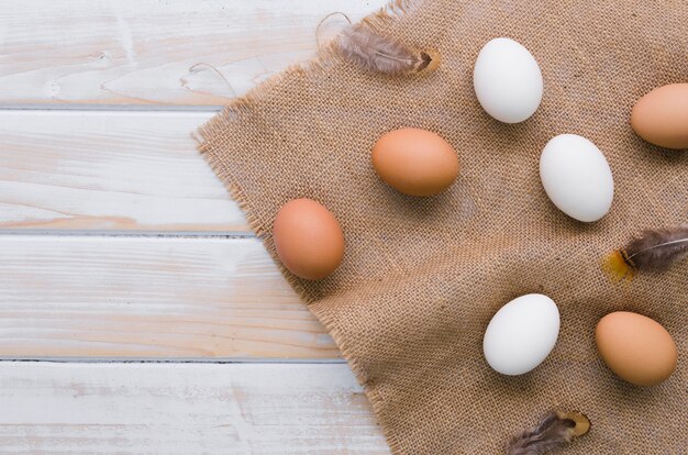 Vue de dessus des oeufs non colorés pour Pâques avec toile de jute et espace copie