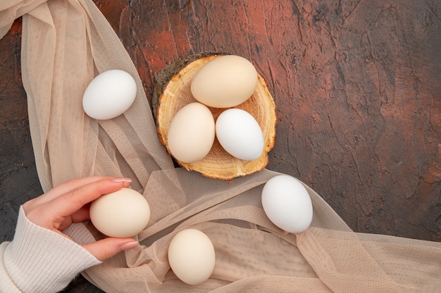 Vue de dessus des œufs de poule blancs sur un bureau sombre repas animal photo brute ferme nourriture petit déjeuner couleur