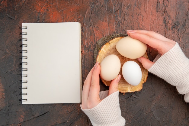 Vue de dessus des œufs de poule blancs sur un repas de table sombre couleur animale photo brute petit-déjeuner alimentaire