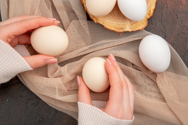 Vue de dessus des œufs de poule blancs sur une table sombre repas animal photo brute couleur du petit-déjeuner à la ferme