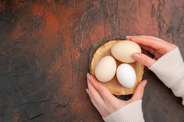 Vue de dessus des œufs de poule blancs sur la table sombre