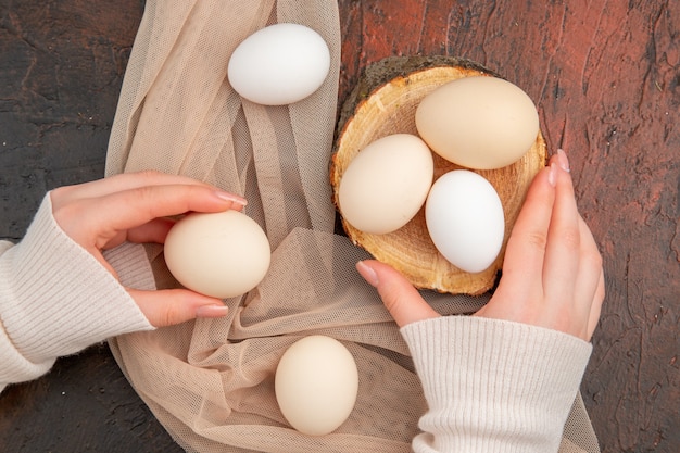 Vue de dessus des œufs de poule blancs sur la table sombre