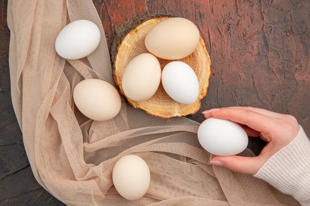 Vue de dessus des œufs de poule blancs sur la table sombre