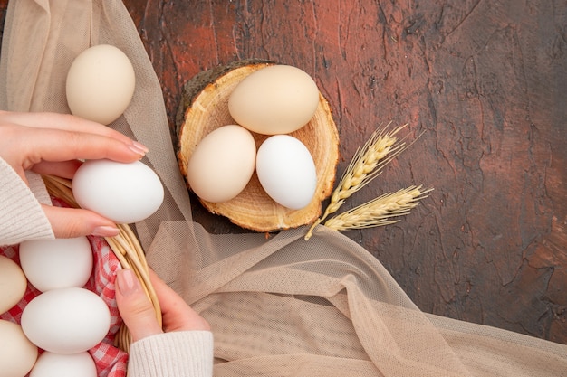 Vue de dessus des œufs de poule blancs sur la table sombre