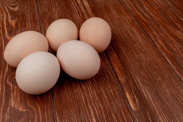 Vue de dessus des œufs de poule frais isolés sur un fond en bois