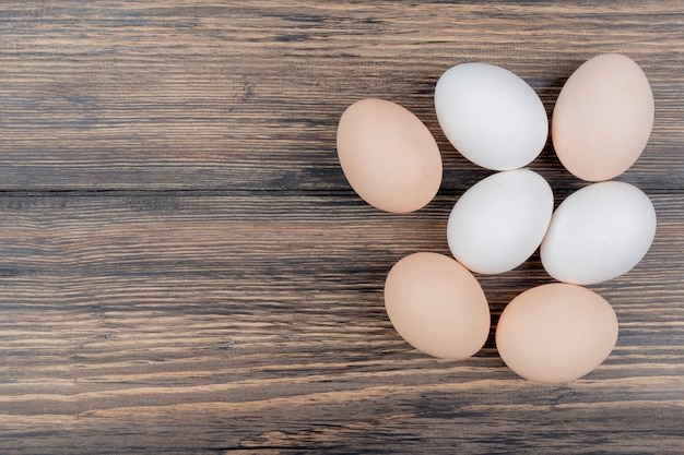 Photo gratuite vue de dessus des œufs de poule isolés sur un fond en bois avec espace copie