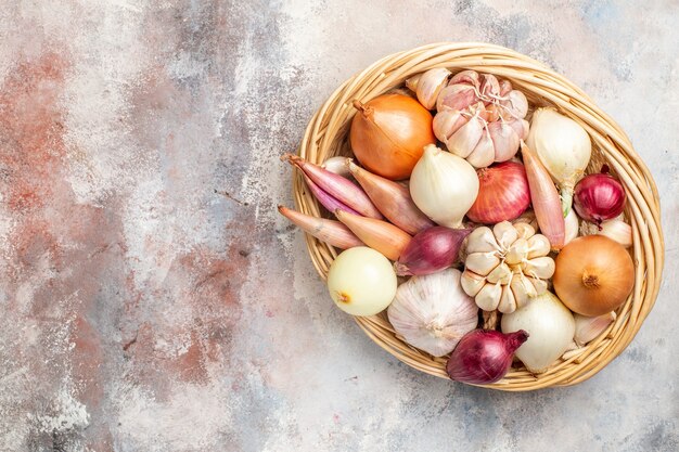 Vue de dessus oignons et ails ingrédients frais à l'intérieur du panier