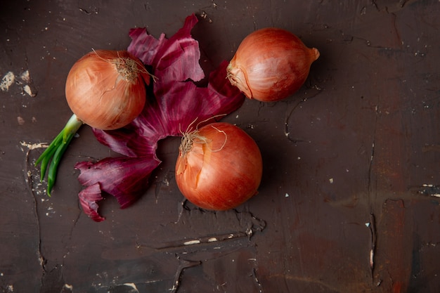 Vue de dessus des oignons et de la coquille d'oignon sur fond marron avec espace copie