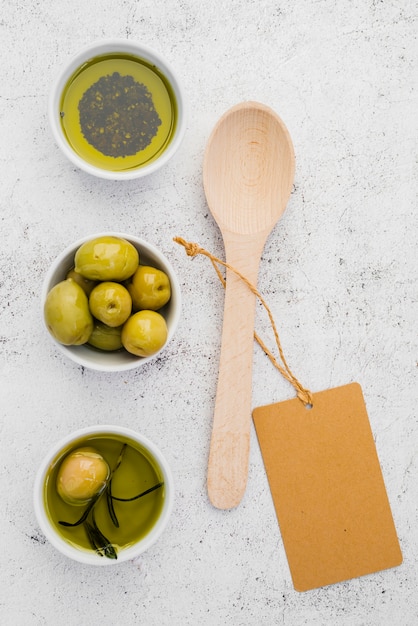 Vue de dessus des olives et de l'huile avec une cuillère