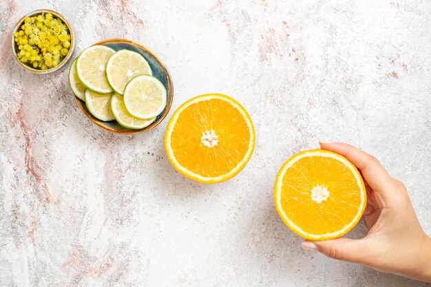 Vue de dessus orange fraîche en tranches avec du citron sur fond blanc couleur des fruits jus d'agrumes frais