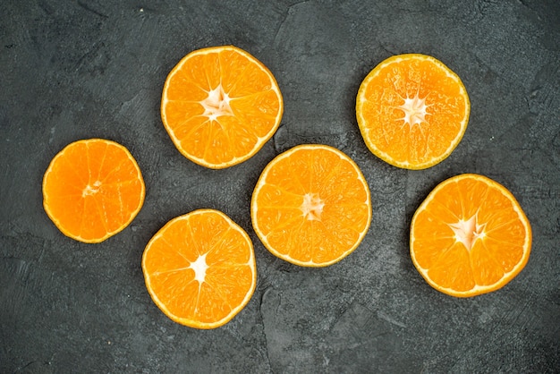 Photo gratuite vue de dessus des oranges coupées sur fond sombre