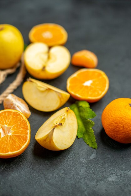 Vue de dessus des oranges coupées et des pommes coupées en orange sur fond sombre