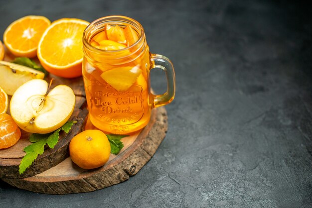 Vue de dessus des oranges coupées et des pommes coupées en orange sur une surface sombre