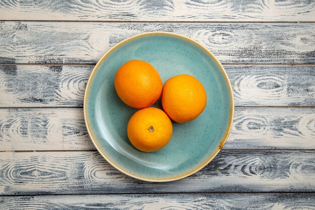 Vue de dessus des oranges fraîches à l'intérieur sur une surface gris-rustique