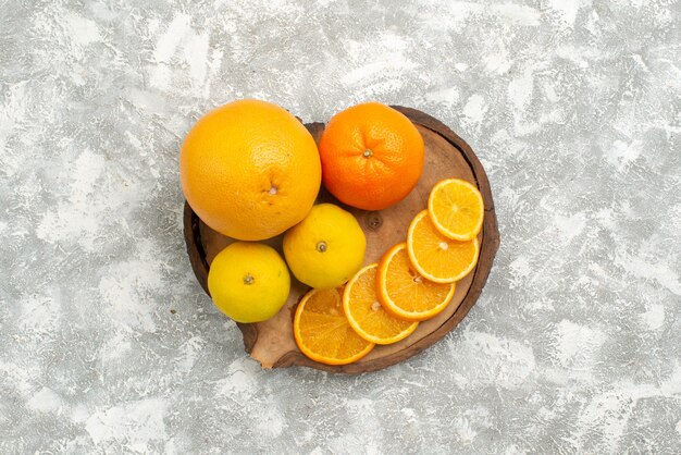 Vue de dessus des oranges fraîches avec des mandarines sur le fond blanc agrumes fruits frais tropicaux exotiques