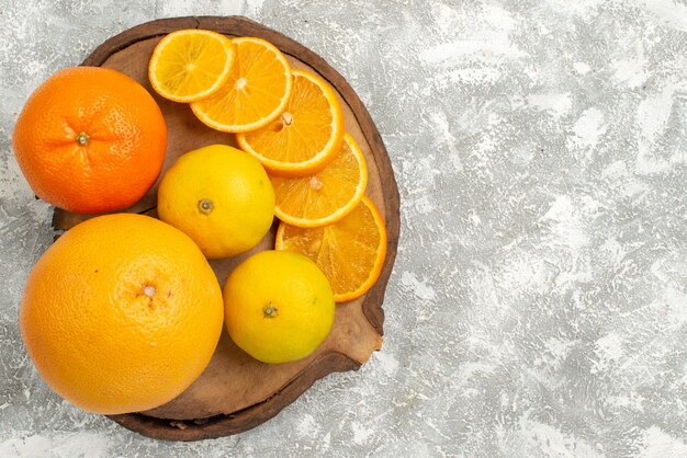 Vue de dessus des oranges fraîches avec des mandarines sur le fond blanc agrumes fruits frais tropicaux exotiques