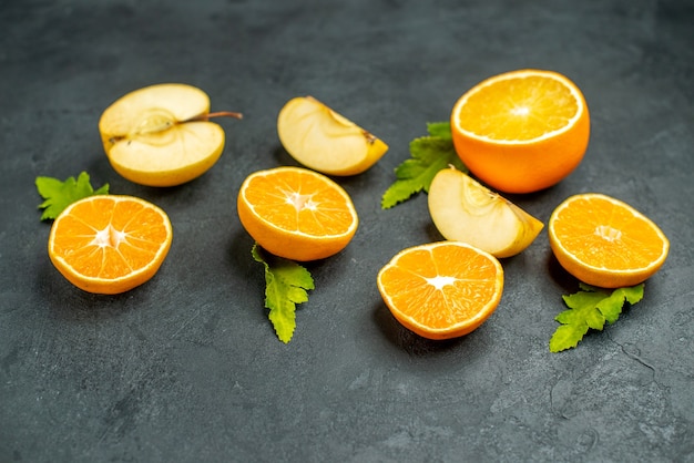 Vue de dessus des oranges et des pommes coupées sur fond sombre