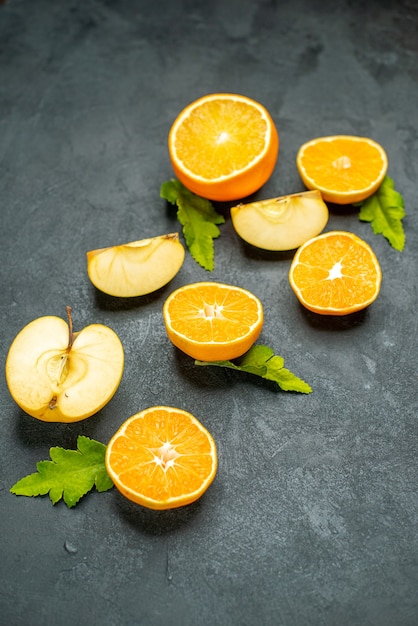 Vue de dessus des oranges et des pommes coupées sur fond sombre