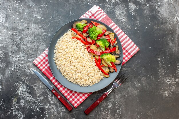 Photo gratuite vue de dessus de l'orge perlé avec de savoureux légumes cuits sur la table grise