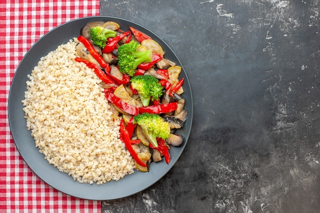 Photo gratuite vue de dessus de l'orge perlé avec de savoureux légumes cuits sur la table grise