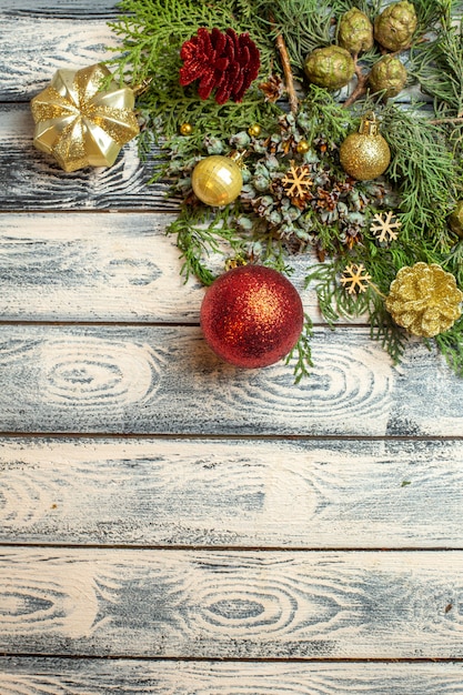 Vue de dessus ornements de noël cadeaux bonbons branches de sapin sur fond de bois espace libre