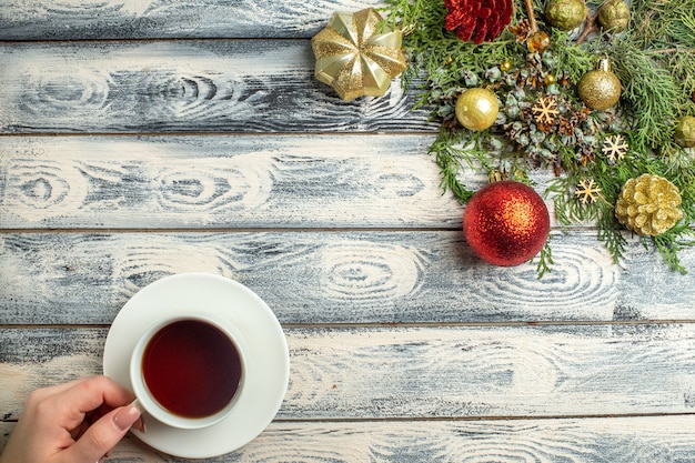 Vue de dessus des ornements de Noël une tasse de branches de sapin à thé sur une surface en bois