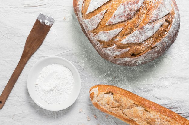 Vue de dessus pain rond et baguette française avec de la farine