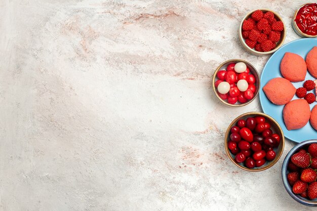 Vue de dessus des pains d'épices roses avec des fruits et des baies sur fond blanc tarte aux biscuits au sucre biscuit gâteau sucré