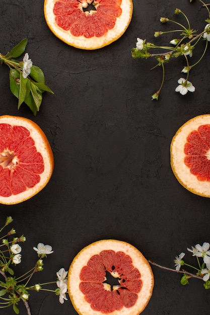 Vue De Dessus De Pamplemousse En Tranches Juteux Avec Fleur Blanche Sur Le Fond Sombre