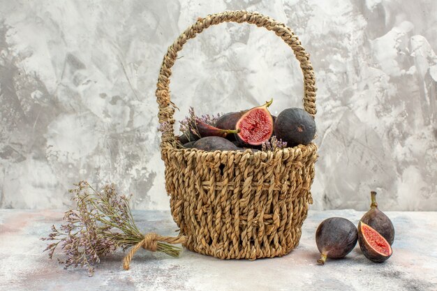 Vue de dessus panier de figues figues bouquet de fleurs séchées sur fond gris