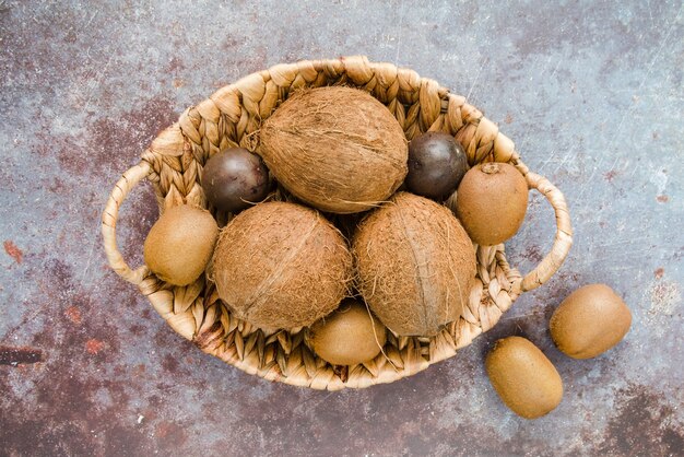 Vue de dessus panier rempli de noix de coco et de kiwi