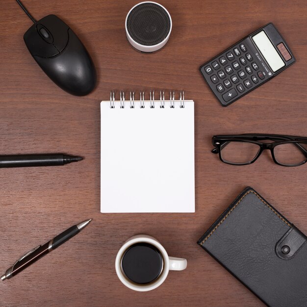 Vue de dessus de la papeterie de bureau; tasse à café; avec haut-parleur Bluetooth; lunettes sur le bureau en bois