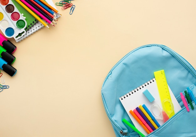 Vue de dessus de la papeterie de retour à l'école avec sac à dos et crayons colorés