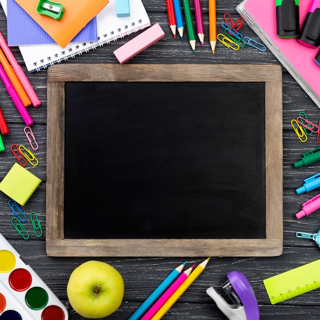 Photo gratuite vue de dessus de la papeterie de retour à l'école avec tableau noir et crayons colorés
