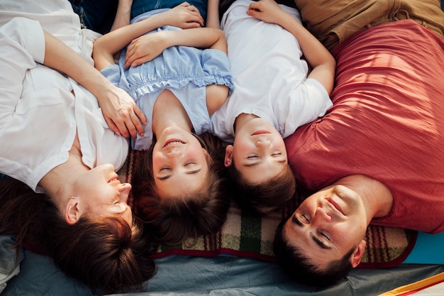 Vue de dessus des parents avec leurs enfants se reposant dans une tente