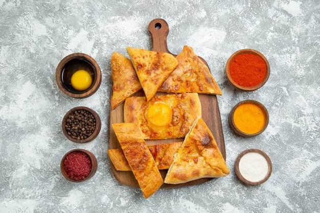 Vue de dessus de la pâte aux oeufs en tranches de pain cuit au four avec assaisonnements sur fond blanc pâte à pâtisserie nourriture repas pain pain