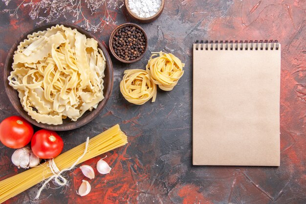 Vue de dessus de la pâte crue en tranches sur la surface sombre de la pâte de pâtes alimentaires sombre